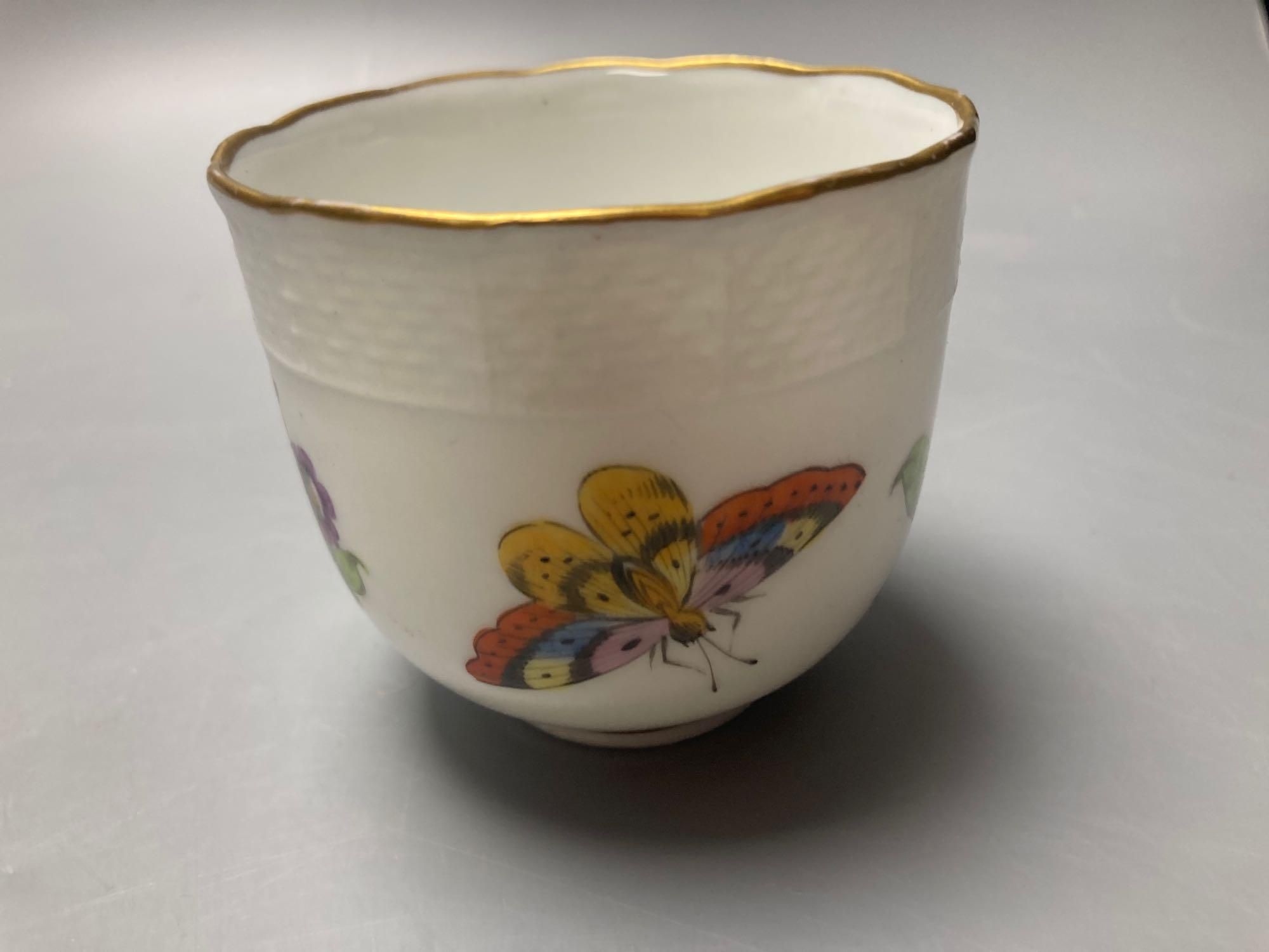 A Meissen cup and saucer, factory seconds, decorated with fruit and butterflies and lined with gilt